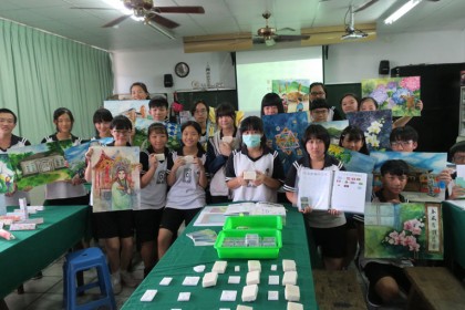 圖：國風國中九年級同學手持各種對稱之美畫作，及創作品，展現學習成果。（記者李婕妤／攝）