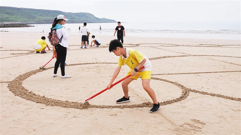 澎湖澎南國中學生自己畫草圖，運用數學中的尺規作圖、垂線原理製作巨型沙畫。圖／王姿翔提供 1