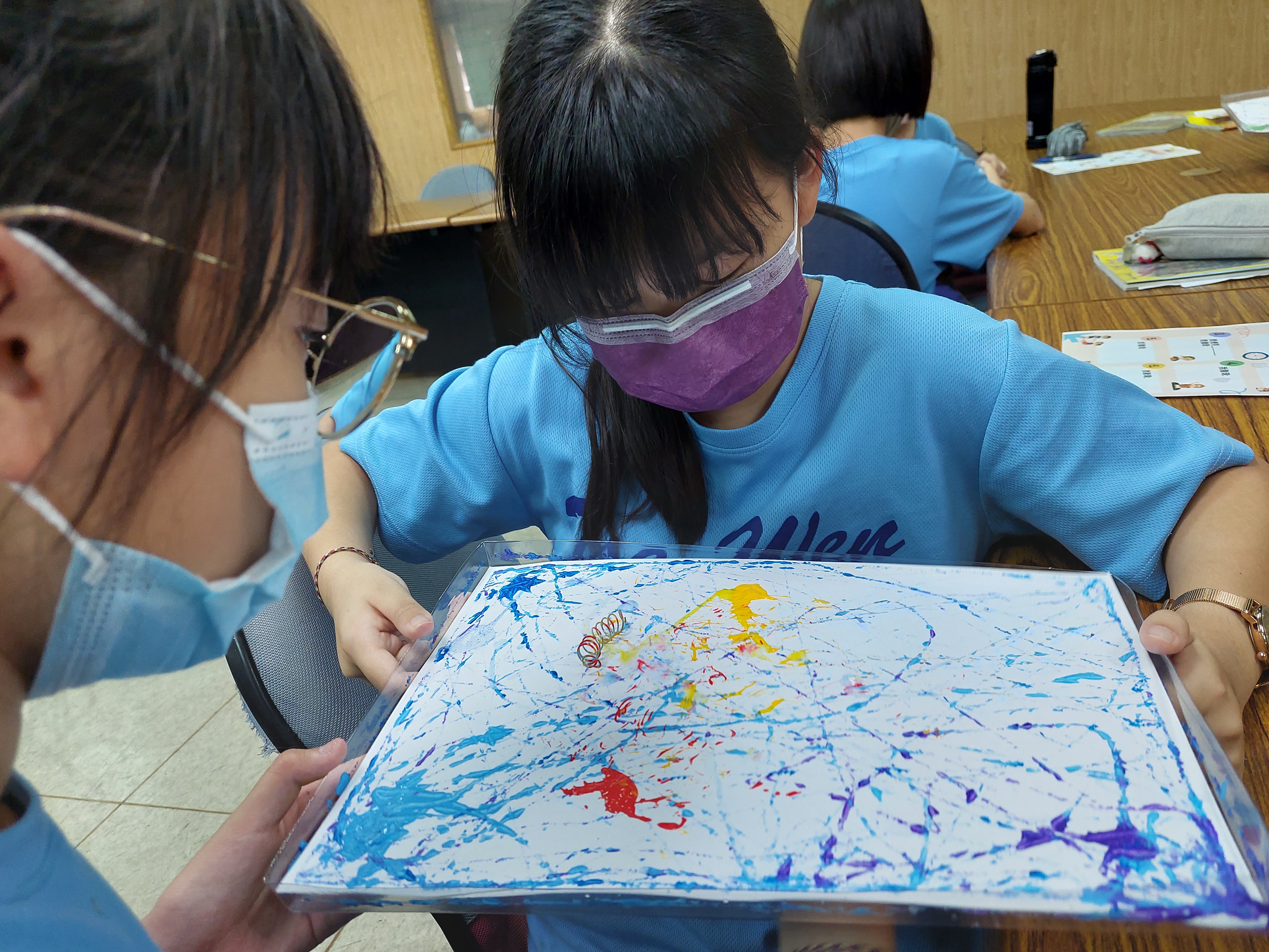 Students use magnets as paintbrushes to design unique magnetic paintings